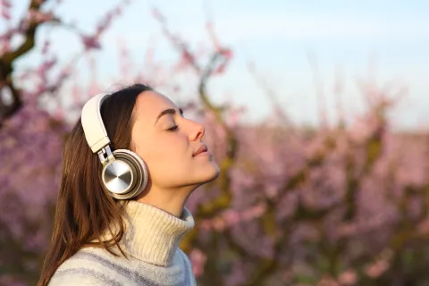 Woman meditating listening audiobook with headphone