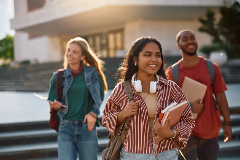 Student going on a lecture at the university. Her friends are in the background.