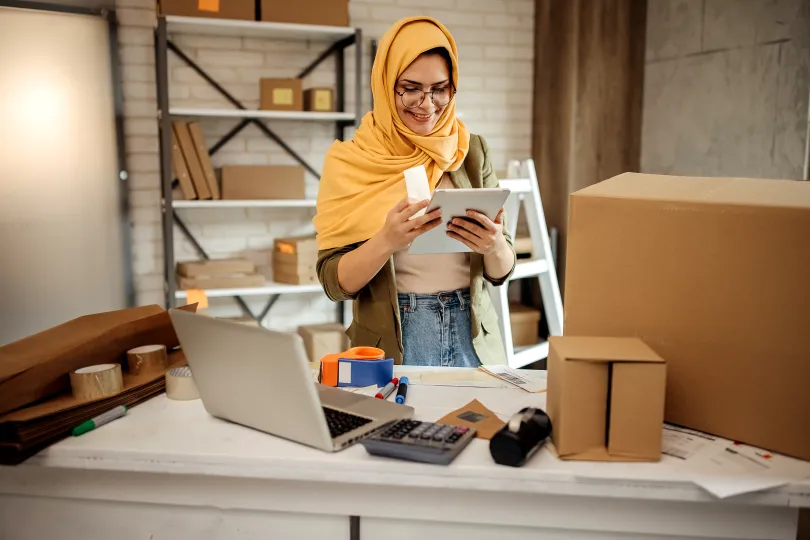 Young woman packing products in box for selling online