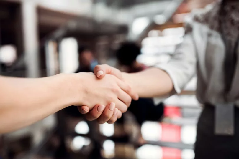 Two people shake hands