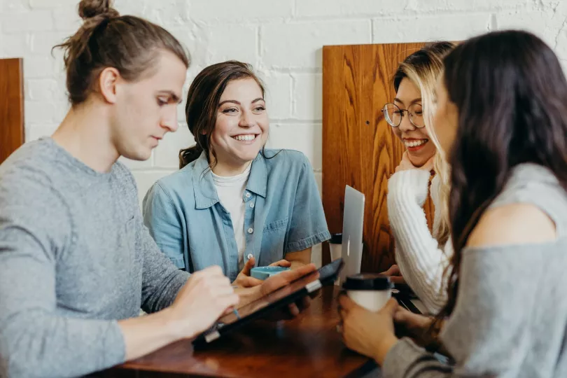 Four people converse around a table