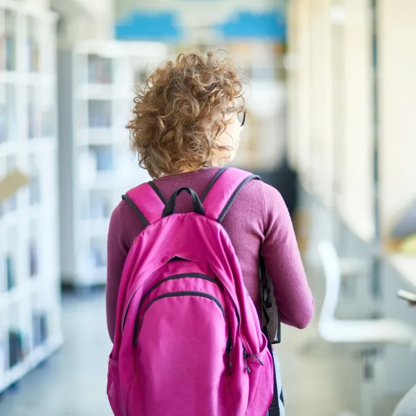 A person in a pink backpack walks away
