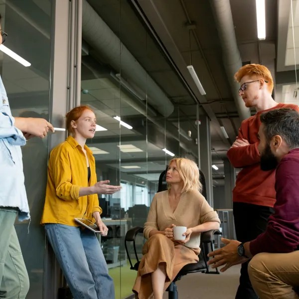 Five people converse in an industrial setting