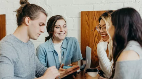 Four people converse around a table