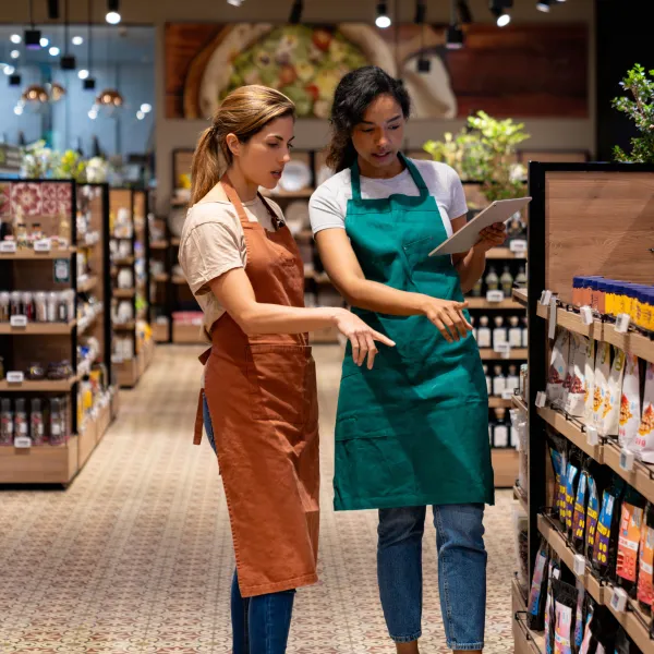 business manager training a new retail clerk at a supermarket 
