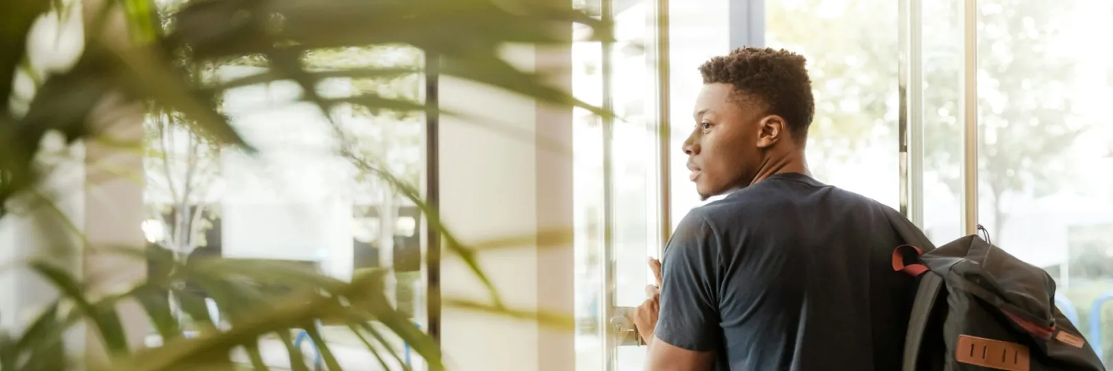 A person with a backpack walks through an academic setting